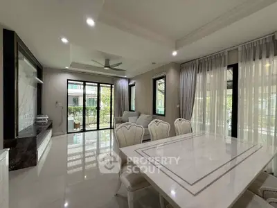 Elegant living room with marble dining table and large windows offering natural light.