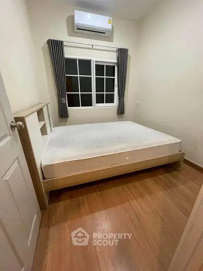 Cozy bedroom with wooden flooring and air conditioning