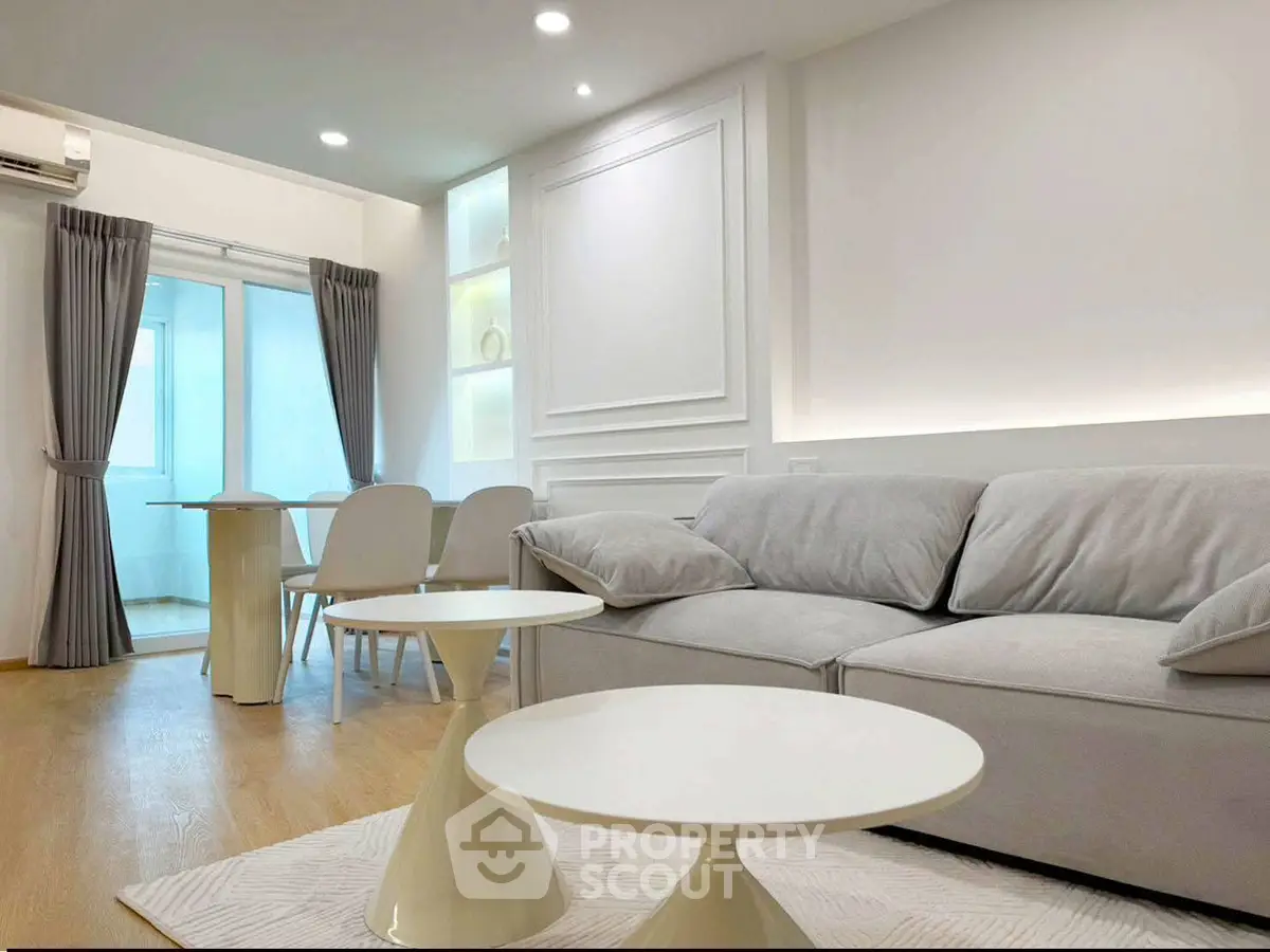 Modern living room with elegant decor and cozy seating area, featuring stylish furniture and ambient lighting.