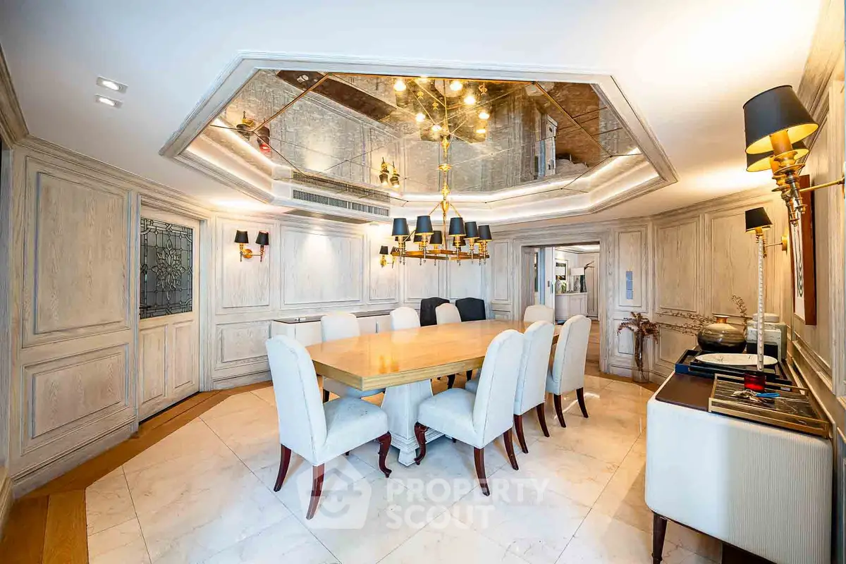 Luxurious dining room with elegant chandelier and mirrored ceiling in upscale home.