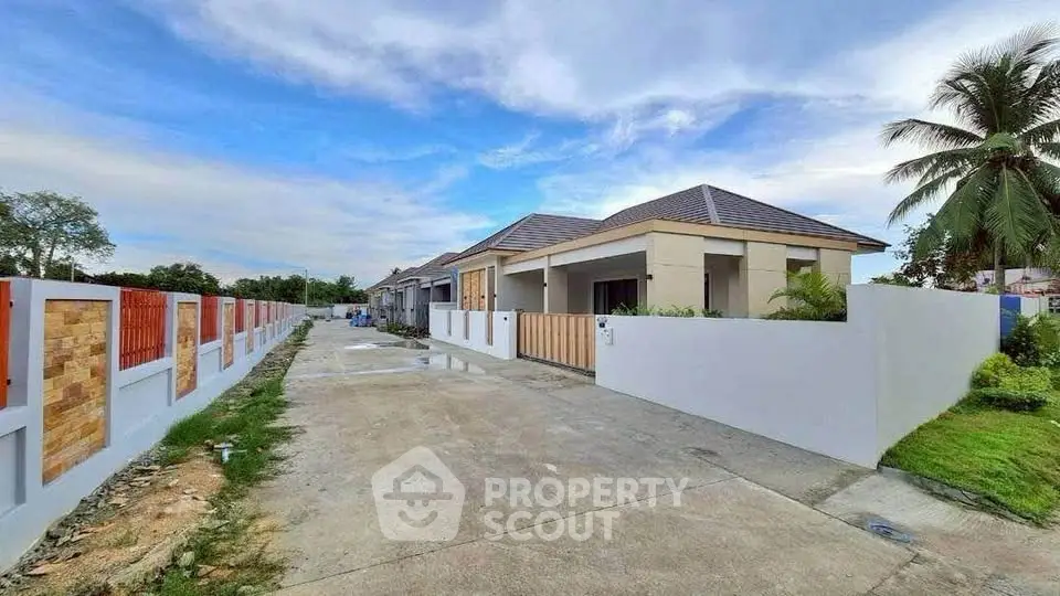 Charming modern bungalow with spacious driveway and lush greenery in serene neighborhood.