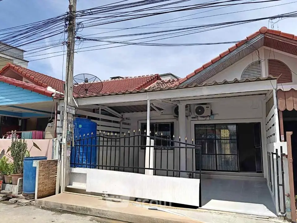 Charming single-story home with gated entrance and tiled roof in a cozy neighborhood.