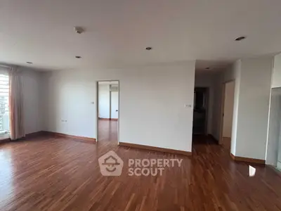 Spacious empty living room with wooden flooring and natural light