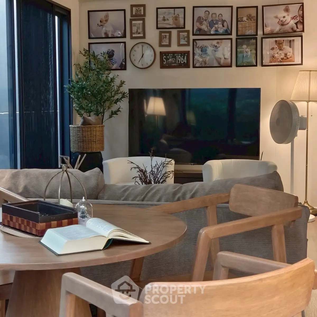 Cozy living room with modern decor, large TV, and gallery wall of family photos.