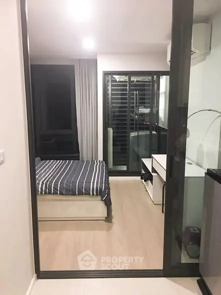 Modern bedroom with sleek design and large windows offering natural light.
