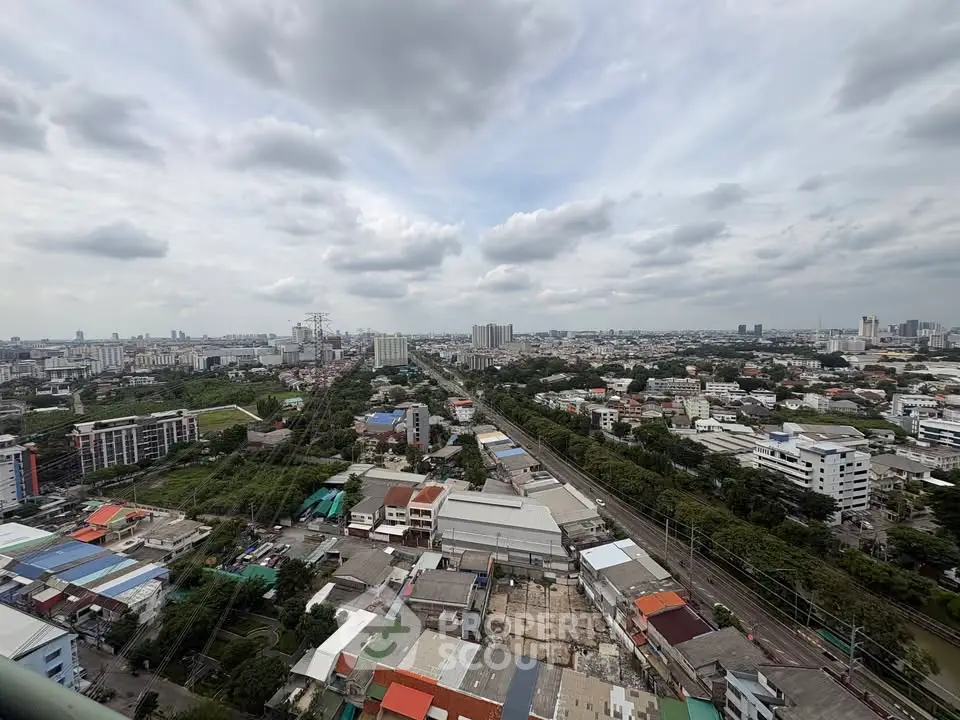 Stunning aerial cityscape view showcasing urban skyline and residential areas under a cloudy sky.