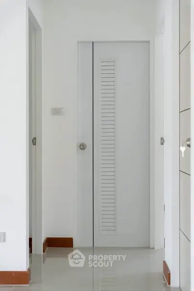Sleek white hallway with modern door and glossy floor tiles