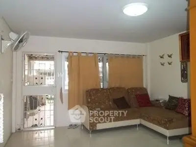 Cozy living room with sectional sofa and large window for natural light.