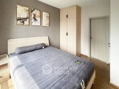 Modern bedroom with stylish decor and wooden furniture, featuring a comfortable bed and elegant wall art.