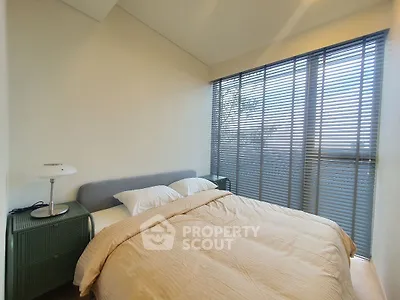 Cozy bedroom with large windows and modern decor, perfect for relaxation and comfort.