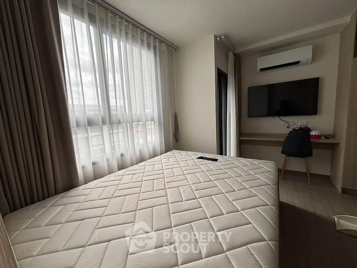 Modern bedroom with large window, air conditioning, and wall-mounted TV in a stylish apartment.