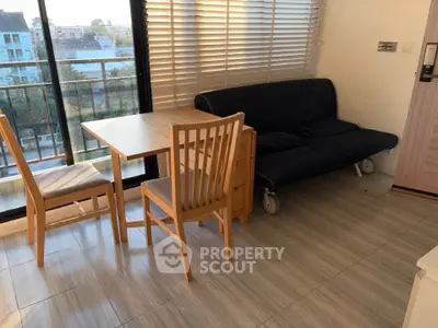 Bright living room with modern furniture and balcony view in urban apartment.