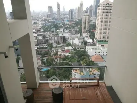Stunning cityscape view from a modern balcony with wooden flooring and seating area.