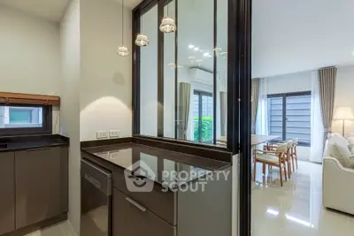 Modern open layout kitchen with sleek countertops and view into spacious living area
