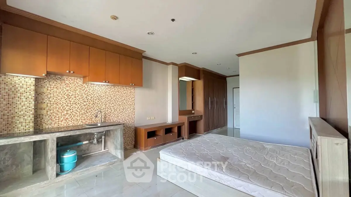 Spacious bedroom with built-in wardrobe and kitchenette in modern apartment