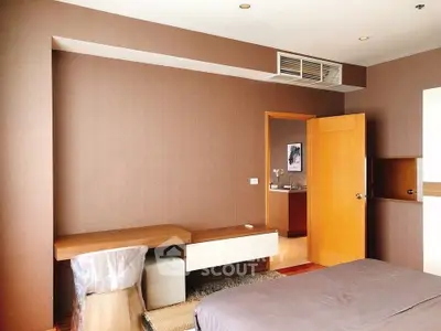 Spacious bedroom with modern decor and wooden furniture, featuring a cozy bed and a stylish desk area.
