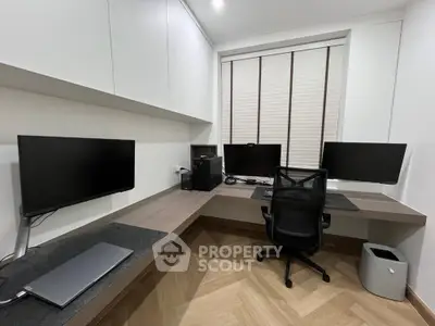Modern home office with sleek desk, multiple monitors, and ergonomic chair