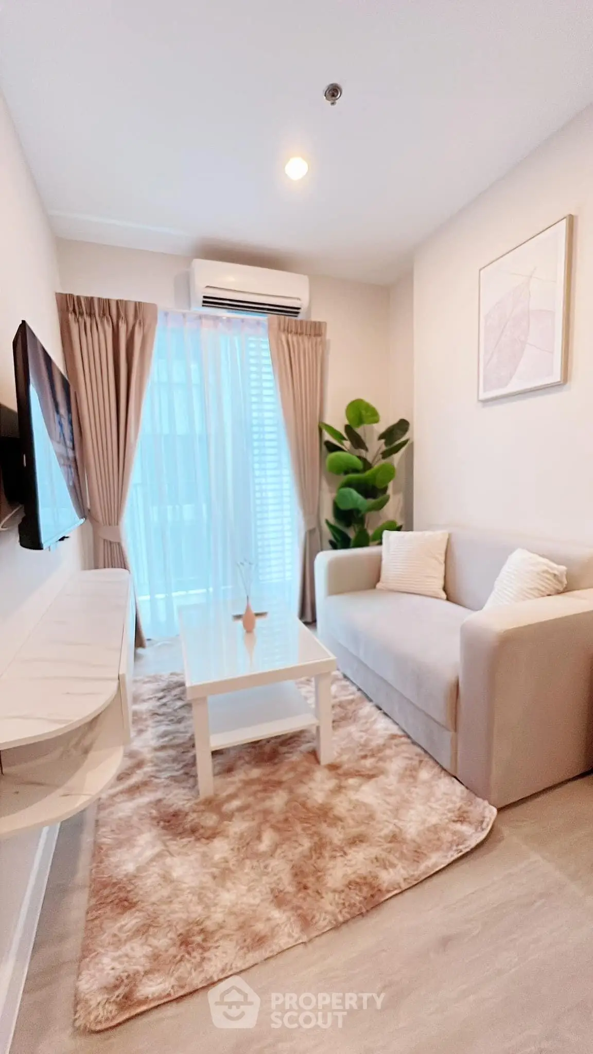 Modern living room with cozy sofa, wall-mounted TV, and large window with curtains.