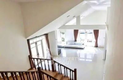 Spacious living room with high ceilings and large windows offering abundant natural light.