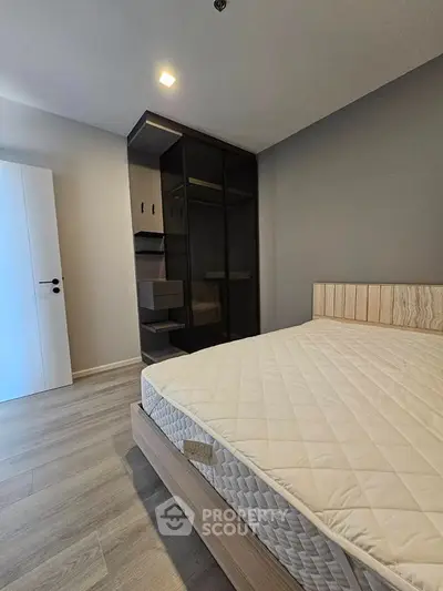 Modern bedroom with sleek wardrobe and comfortable bed in stylish apartment.