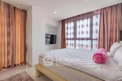 Spacious bedroom with large windows and elegant curtains, perfect for natural light lovers.