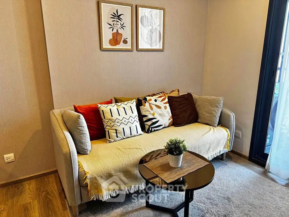 Cozy living room with stylish sofa, decorative pillows, and modern art on the wall.