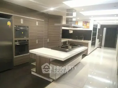 Luxurious modern kitchen with sleek cabinetry and island, featuring built-in appliances and elegant lighting.