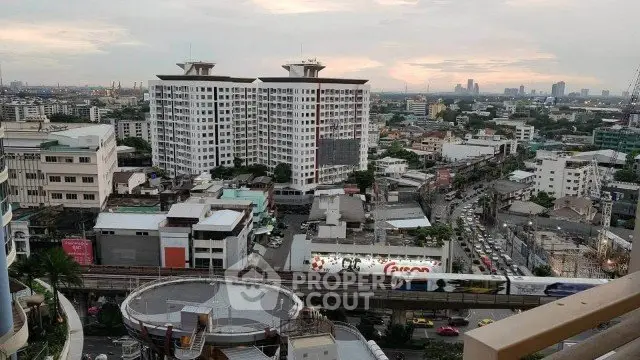 Stunning cityscape view from a high-rise balcony overlooking urban skyline and bustling streets.