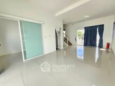 Spacious modern living room with glossy tile flooring and large windows for natural light.
