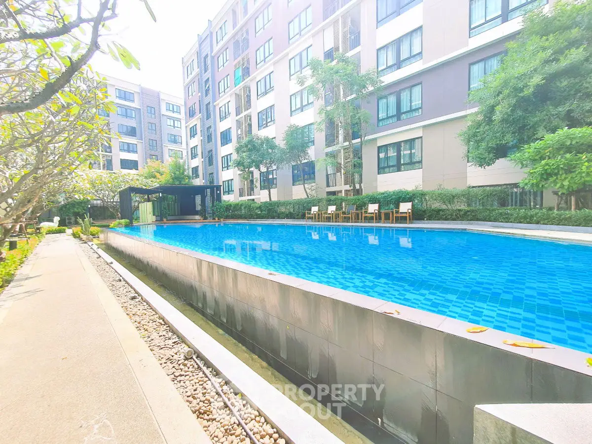 Luxurious apartment complex with a stunning outdoor pool and lush greenery.