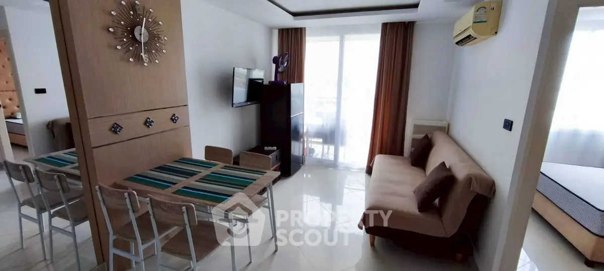 Modern living room with stylish decor and natural light, featuring a cozy sofa and dining area.