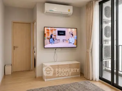 Modern living room with wall-mounted TV and air conditioning, featuring a sliding glass door to balcony.