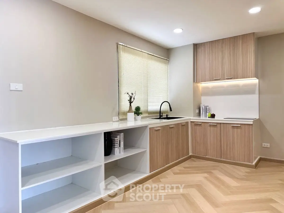 Modern kitchen with sleek wooden cabinets and open shelving in a bright, minimalist design.