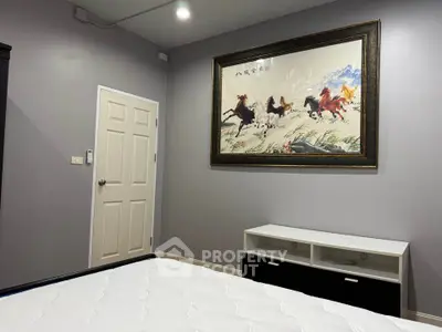Modern bedroom with elegant decor and framed artwork, showcasing a serene and stylish living space.