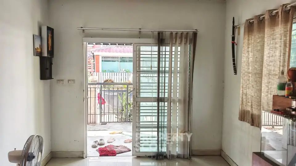 Bright living room with sliding glass doors leading to a balcony, offering ample natural light and outdoor access.