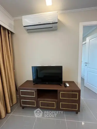 Modern living room with sleek TV stand and air conditioning unit, perfect for cozy entertainment.