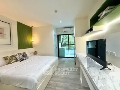 Modern bedroom with stylish decor and balcony view, featuring a sleek TV and elegant furnishings.