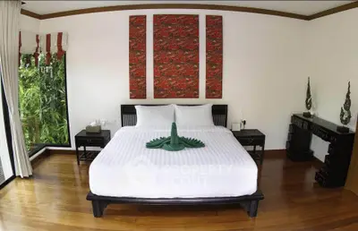 Luxurious bedroom with elegant decor and garden view, featuring a king-sized bed and stylish furnishings.