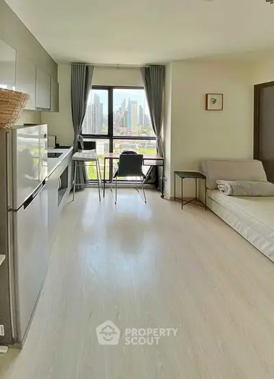 Modern studio apartment with city view, featuring sleek kitchen and cozy living area.
