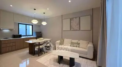 Modern open-layout living room with kitchen, stylish decor, and cozy seating area.