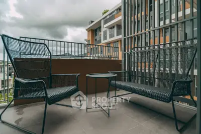 Modern balcony with stylish outdoor furniture and scenic view of contemporary building.