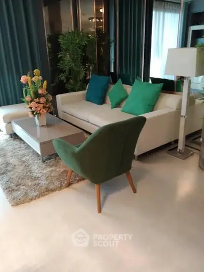 Stylish living room with modern furniture and green accents, perfect for relaxation and entertaining.