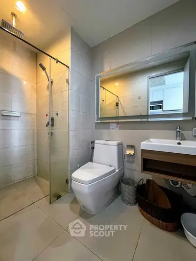 Modern bathroom with glass shower and sleek fixtures in a contemporary home.
