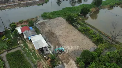 Aerial view of land plot with construction equipment near water bodies, ideal for development.