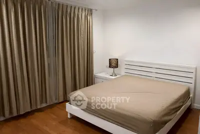 Cozy bedroom with elegant curtains and modern lamp, perfect for relaxation.