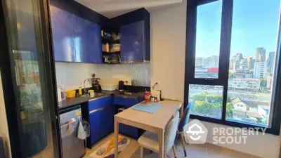 Modern kitchen with blue cabinets and city view, featuring a cozy dining area.