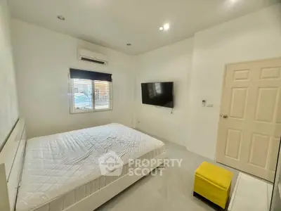 Modern bedroom with wall-mounted TV and air conditioning