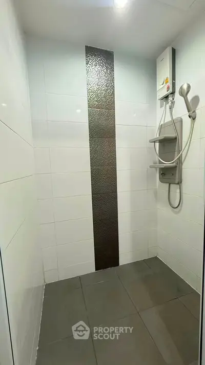Modern bathroom shower area with sleek tiles and water heater