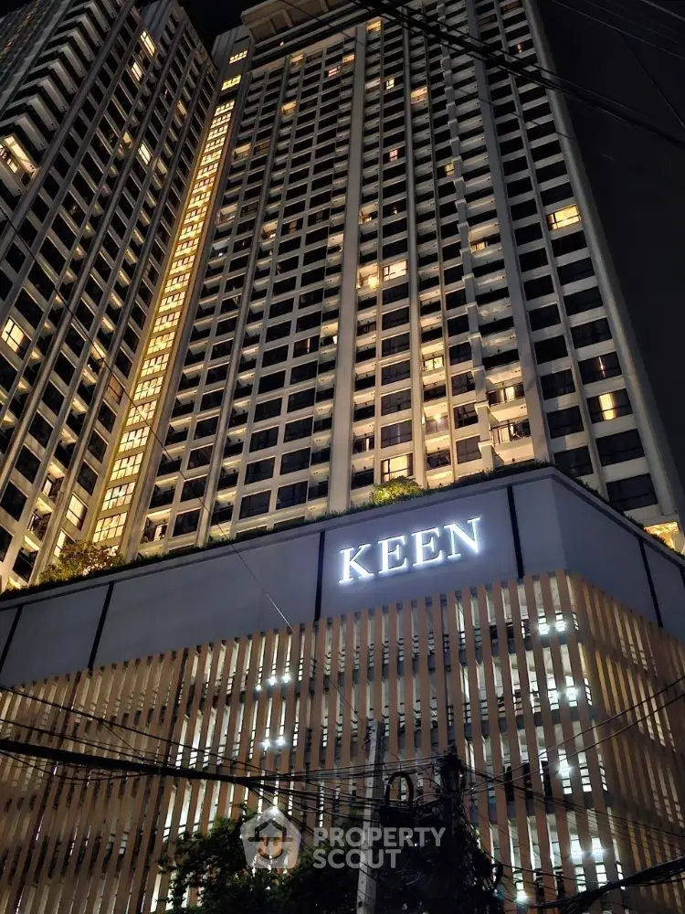 Stunning night view of a modern high-rise building with illuminated windows and sleek architectural design.