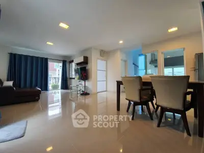Spacious modern living room with dining area and large windows for natural light.